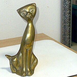 BRASS CAT FIGURINE. 7 1/2” L